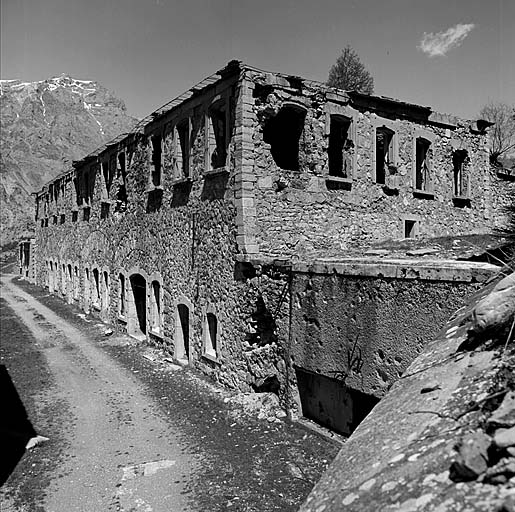 Casernement de temps de paix. Bâtiment 002 (casemates de l'ancienne redoute surmontées d'un étage en 1931-1935). Vue d'ensemble. A droite, fossé du flanc droit de l'ouvrage avec, dans le ressaut, le bloc 7 (cheminée).