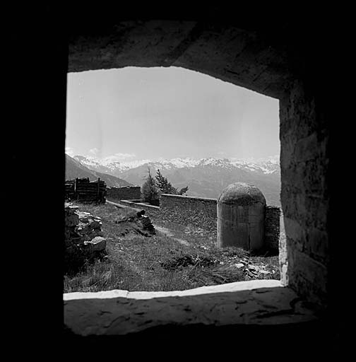 Terre-plein supérieur de l'ouvrage vu par une fenêtre du poste optique. A droite, tourelle de l'escalier venant du casernement. A l'arrière-plan, les cimes du massif de Restefond.