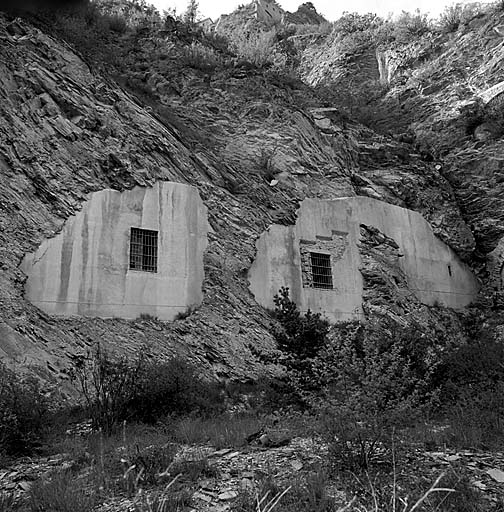 Batterie XII. Façade des casemates de la courtine. Vue intérieure prise du fossé. Au centre (casemate 13) on remarque le tracé de l'embrasure bétonnée d'un 155c, bouchée ultérieurement et remplacée par une fenêtre ordinaire.