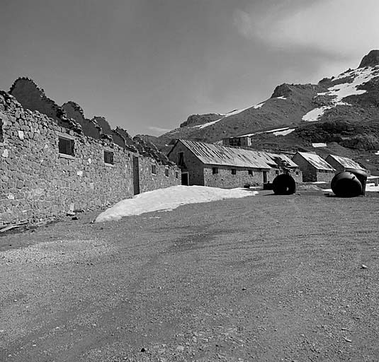 Partie basse du site. De gauche à droite, écuries h, g, j et i. Au second plan, le casernement défensif et le pavillon f. Sur le terre-plein, cuirassements en dépôt.