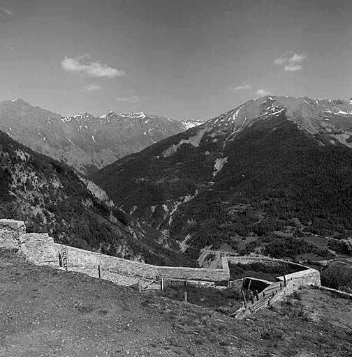 Vue prise vers le sud-est. Au premier plan, le parapet du front de tête. Derrière, à gauche, le vallon de Sagnes (torrent d'Abriès).