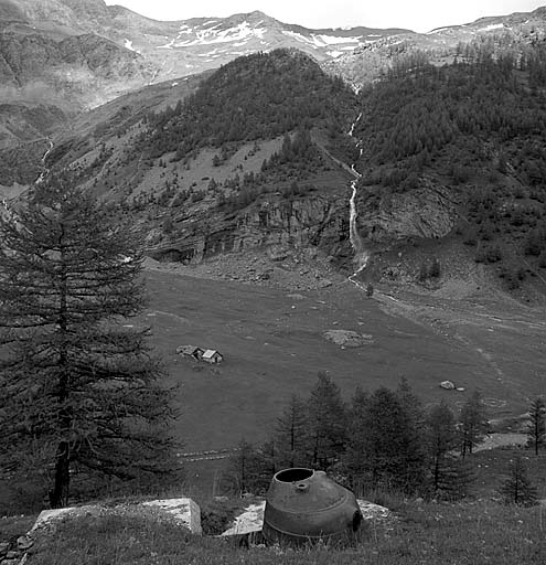 Vallée du torrent d'Abriès vue du point d'appui. Au premier plan, tourelle de mitrailleuse par éléments de gauche. En bas, à droite, emplacements de tentes d'un cantonnement militaire. En arrière, cascade des Sagnes.