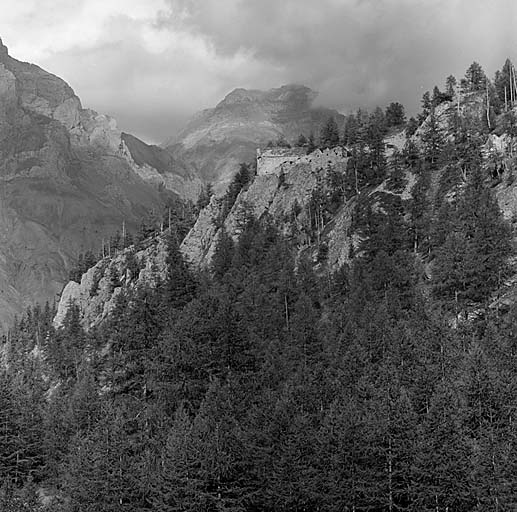 Vue d'ensemble de l'ouvrage prise de l'arrière, depuis la route d'accès. Au fond, à gauche, les rochers de Saint-Ours. Au centre, la Rocca Bianca.