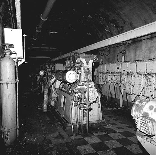 Usine (local 75). Salle des groupes. Au premier plan, deuxième groupe, à droite, excitatrice du troisième groupe. Derrière, tableau de distribution.