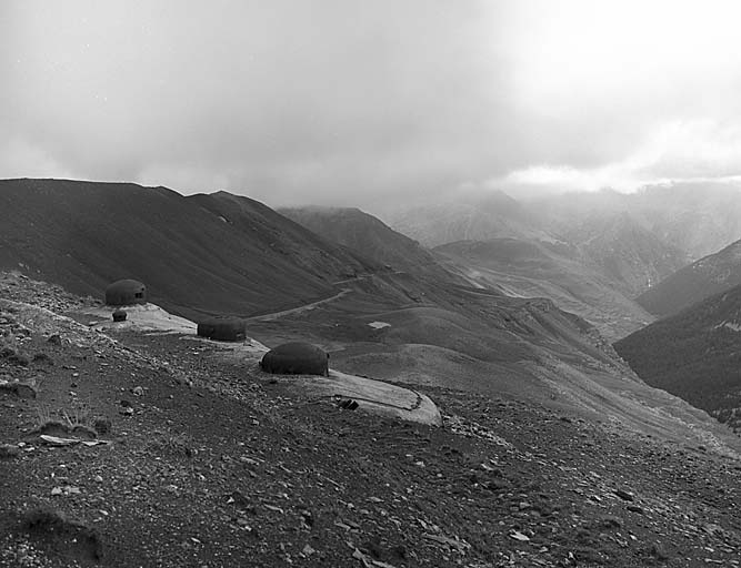 Bloc 4. Vue de dessus prise de l'arrière et montrant le bassin des sources de la Tinée, battu par les jumelages de mitrailleuses des blocs 3 et 4. A gauche, crête des Trois Serrières et route descendant vers Nice.