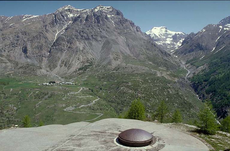 Bloc 5. Vue générale des dessus. Au centre, la tourelle. Derrière village et rochers de Saint-Ours avec, à droite, l'ouvrage haut de Saint-Ours. A droite le torrent du Pinet, et, à l'arrière-plan, la Rocca Bianca.