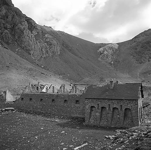 Vue, en premier plan, du casernement et du fond de la combe. En haut, à l'extrémité droite, batterie de Viraysse. Au centre, au pied du rocher isolé se trouve la source dont le captage alimente en eau le casernement.