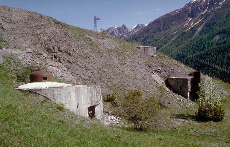 Vue d'ensemble extérieure. Au premier plan, le bloc 1 et sa cloche, au second, le bloc 2. En fond, versant nord-est de la Crête de la Duyère, de l'autre côté de l'Ubayette.