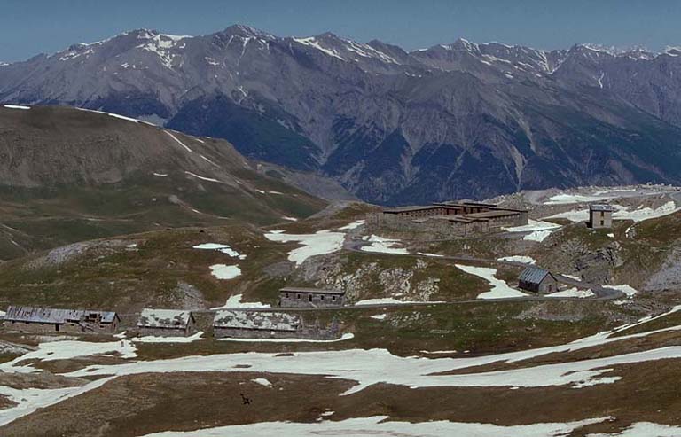 Le site et une partie des bâtiments vus de l'est depuis la route du col. De gauche à droite, écuries g, j, i, cuisine k, casernement défensif et cuisine l.