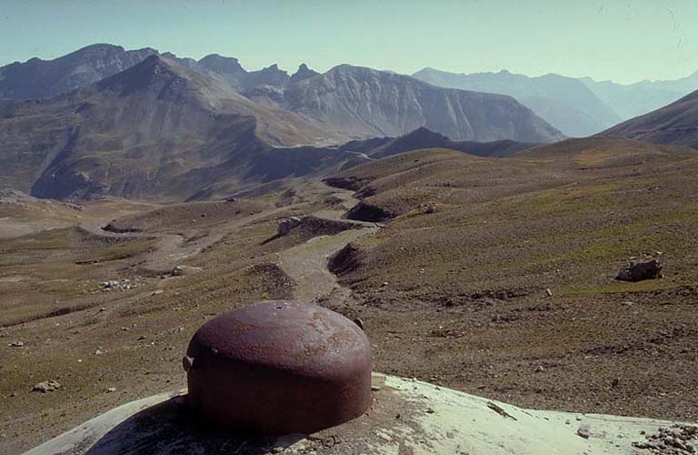 Vue prise du dessus du bloc actif (B3) en direction de l'est, vers le vallon des Granges Communes. L'ouvrage des Granges Communes et col, le fortin et sommet de la Pelousette. Le chemin est l'ancien chemin militaire du camp des Fourches.