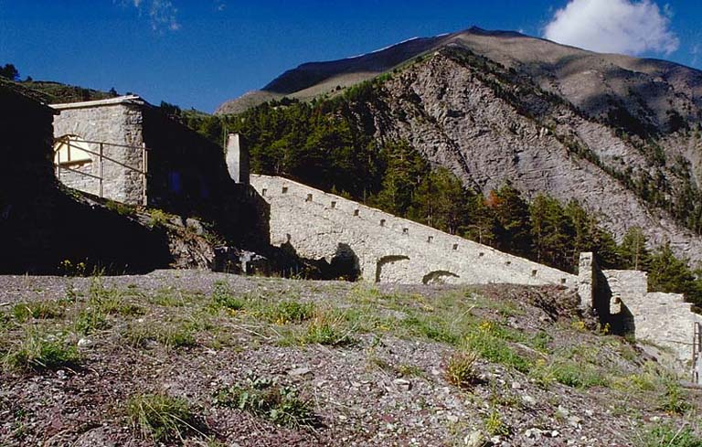 Vue intérieure prise vers le flanc gauche. A gauche, tête de la casemate E. A l'arrière-plan, crête du Signal de la Condamine et les deux postes.