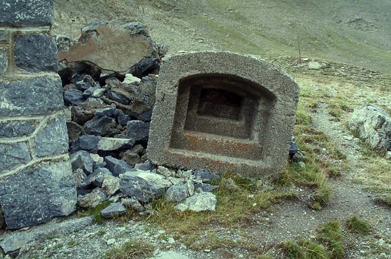 Elément de créneau préfabriqué en béton détaché dans un éboulement d'escarpe.