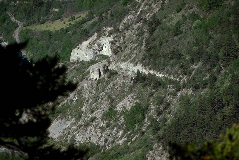 Batterie XII. Télévue du front de l'ouvrage prise de la route de Roche-la-Croix. A droite, casemate f de 95 mm. En bas, à gauche, caserne Pellegrin.