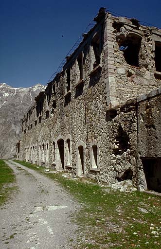 Casernement de temps de paix. Bâtiment 002 (casemates de l'ancienne redoute surmontées d'un étage en 1931-1935). Vue d'ensemble. A droite, fossé du flanc droit de l'ouvrage avec, dans le ressaut, le bloc 7 (cheminée).