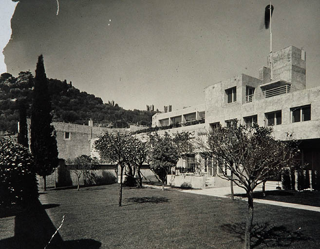 Vue d'ensemble de la villa prise depuis le jardin clos. Au fond au centre, le bâtiment de la piscine.