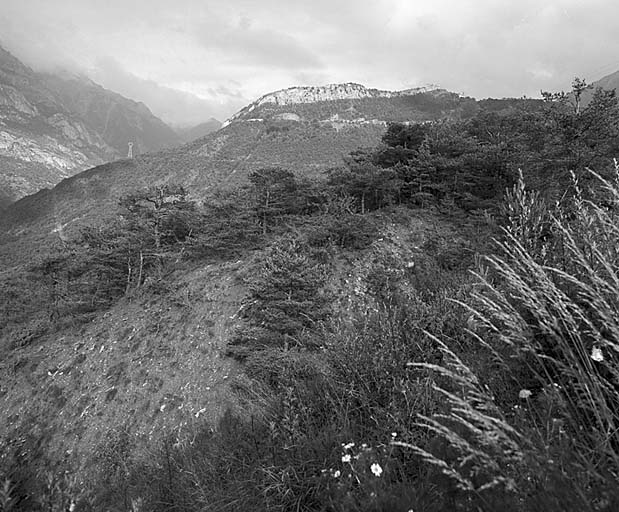 Vue lointaine prise de l'ouest. A gauche, vallée de l'Ubaye. F : le fort, T : la tour à mâchicoulis 18.