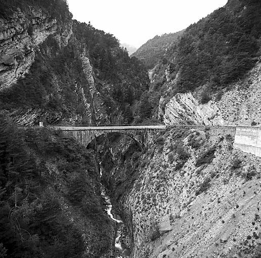 Ancien pont de la D 900 vu du nouveau pont. Le poste crénelé est situé à l'arrière-plan, dans la pente boisée.