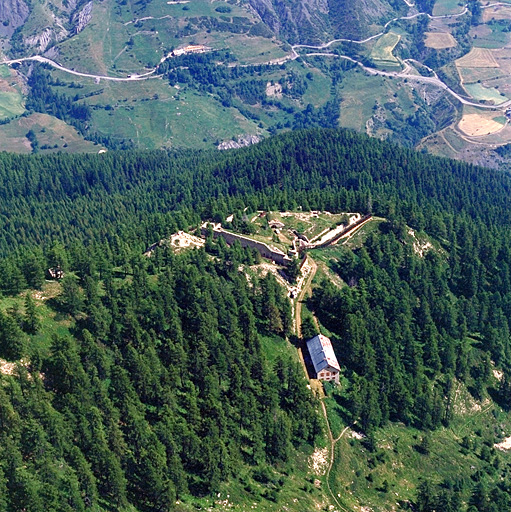 Vue aérienne prise du sud-ouest. A l'arrière plan, montée du col de Vars.