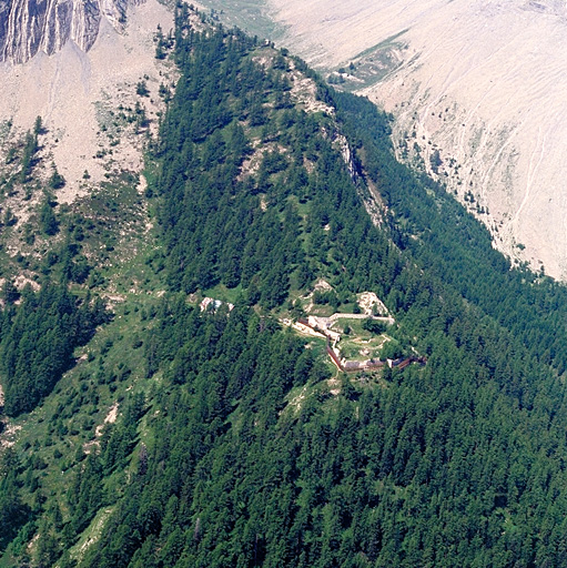 Vue aérienne prise de l'est. Derrière, l'arête rocheuse portant les postes.