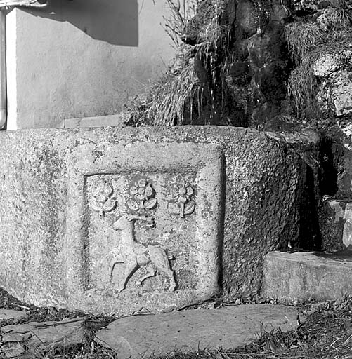 La fontaine actuelle. Sur le bassin en remploi, les armes de la famille du Serre.