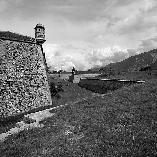 Front d'Eygliers. Vue d'enfilade du fossé du front 1-2 pris de la contregarde 44. Au premier plan, à gauche, saillant du bastion 1. Au deuxième plan, à droite, flanc de la demi-lune 42. Au fond, flanc droit du bastion n° 2.