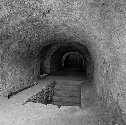 Lunette 64. Vue intérieure de la traverse casematée. Au sol, débouché de l'escalier d'accès. A droite et à gauche, sorties sur le terre-plein de la lunette.