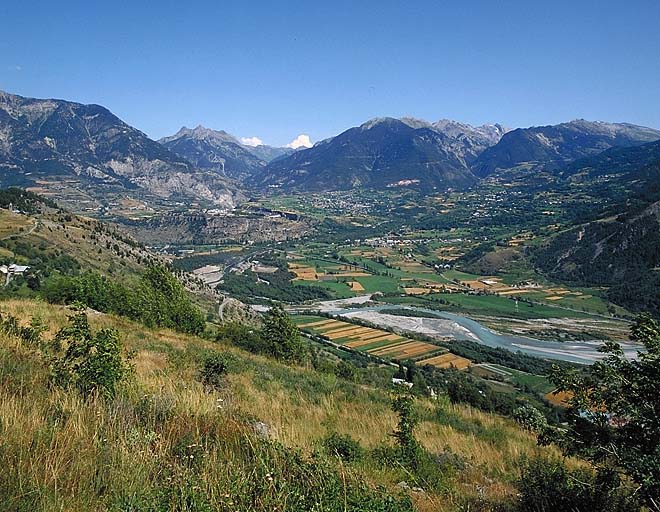 Vue de situation lointaine prise de l'ouest. A droite Guillestre et la descente du col de Vars.