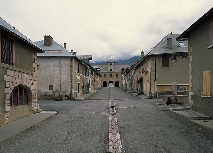 La rue Catinat vue en enfilade. Au premier plan, carrefour de la rue Colonel Cabrié et fontaine. Au fond, pavillon D (porte de Briançon).