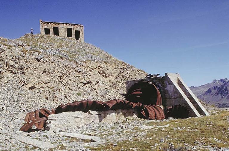 Au sommet le blockhaus, vu du sud-ouest. Au premier plan, restes d'un abri alpin en tôles cintrées resté inachevé.