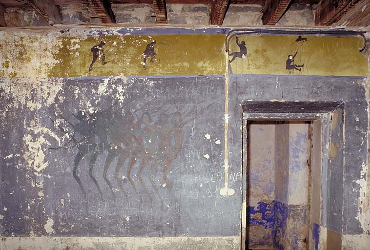 Bâtiment 16, peinture murale. On distingue une troupe de danseuses sur le fond bleu. En frise sur fond jaune, chasseurs alpins à l'exercice.