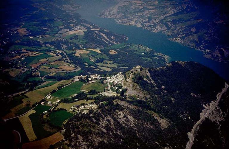 Vue aérienne générale du fort et du village prise du sud-est. En arrière, branche sud du lac de Serre-Ponçon.