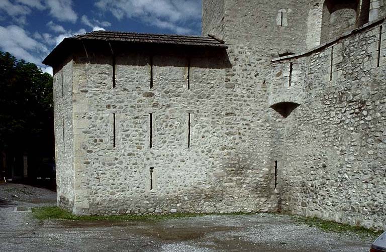 Front sud-est. Tour de la Sacristie et, derrière, la base du clocher et les murs de l'église.