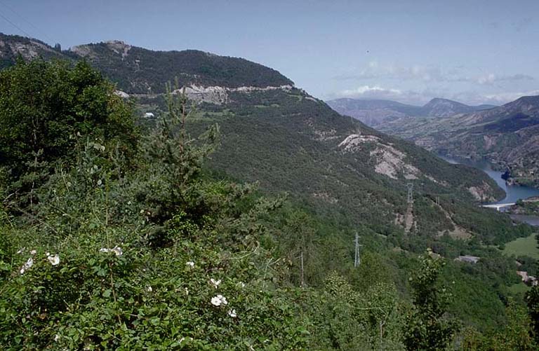 Vue lointaine prise de l'est. A droite l'extrémité du lac de Serre-Ponçon. Sur le point culminant le fort, et un peu plus bas la tour à mâchicoulis 18.