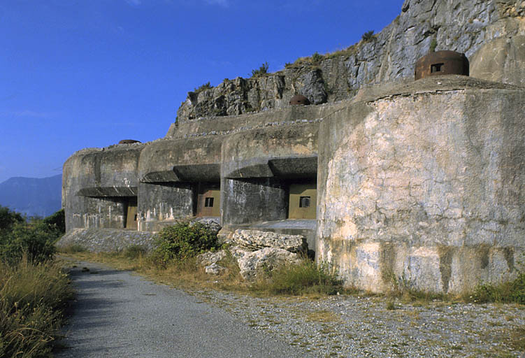 Rimplas, ouvrage mixte dit ouvrage de la Madeleine, dit ouvrage de Rimplas. ; Secteur fortifié des Alpes-Maritimes. Rimplas. Ouvrage de la Madeleine. ; Bloc 5 (casemate Valdeblore). Ensemble de la façade vu du nord. A gauche, casemate cuirassée du mortier de 75-31 avec, au-dessus, cloche observatoire VDP. A droite, les deux casemates cuirassées des canons obusiers de 75-33 et cloche GFM.