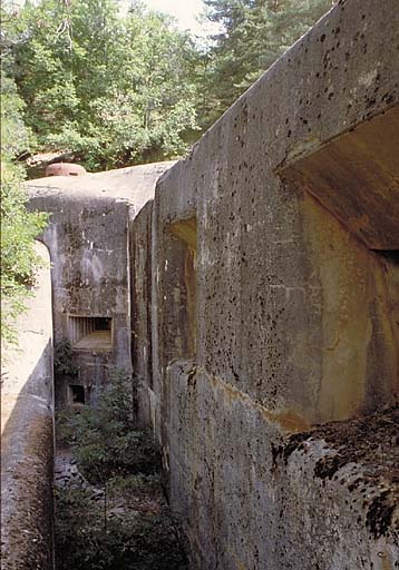 Bloc 3. Vue oblique de la façade nord. A droite, casemates cuirassées des 75/33. Au fond, au-dessus, cloche observatoire VDP. Au milieu, créneau FM de défense de façade. En dessus, issue de secours.