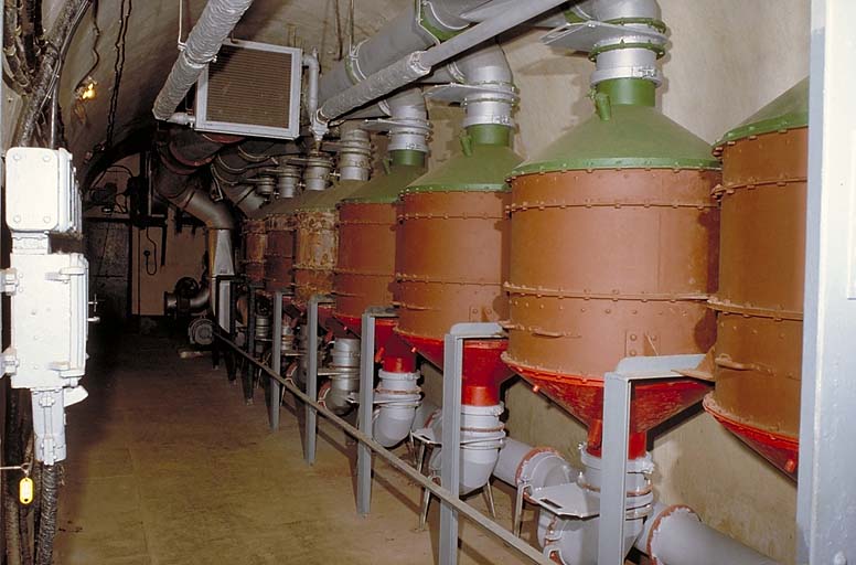 Salle de neutralisation. Vue prise depuis la galerie centrale. A droite, la batterie de filtres. En haut, au centre, bouche de soufflage et batterie chauffante. Au fond, à gauche, porte du sas de la galerie du bloc 2.