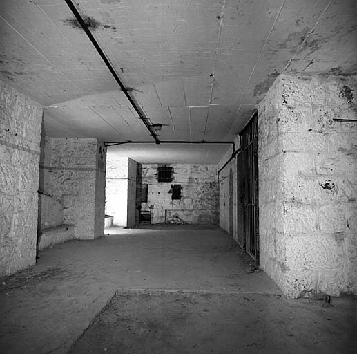 Caponnière sud. Vue intérieure prise d'enfilade vers l'ouest. Au fond, mur de masque et embrasure à canon. A droite, porte de la galerie d'accès. Au-dessus, dalle de béton de renforcement remplaçant la voûte.