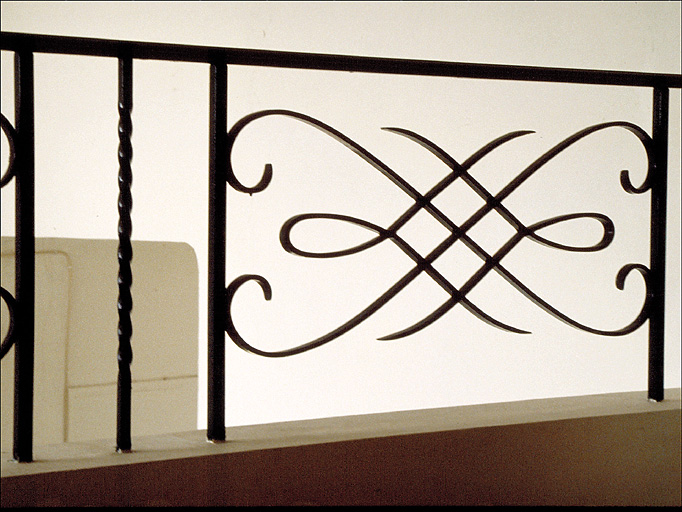 Détail de la rampe en fer-forgé de la cage d'escalier.