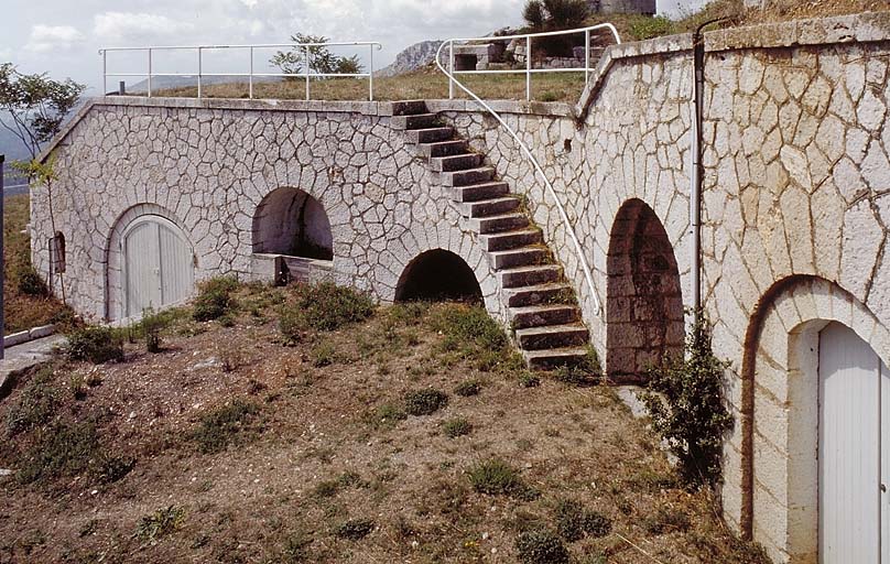 Banquette d'artillerie. A droite, façade postérieure de l'abri 4 (casemate à feux courbes) ; à gauche, façade postérieure de l'abri 3 et escalier d'accès à la plateforme 6.