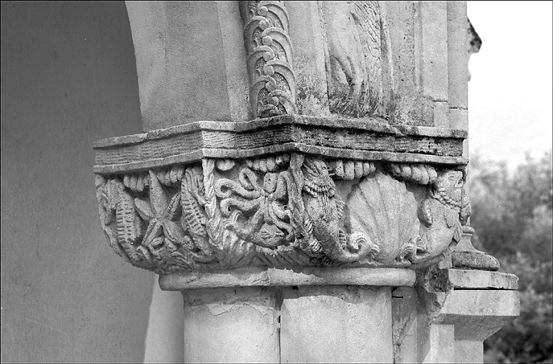 Chapelle. Détail, chapiteau à droite du porche d'entrée sculpté d'animaux marins : poissons, coquille Saint Jacques, pieuvre, étoile de mer et hippocampes.