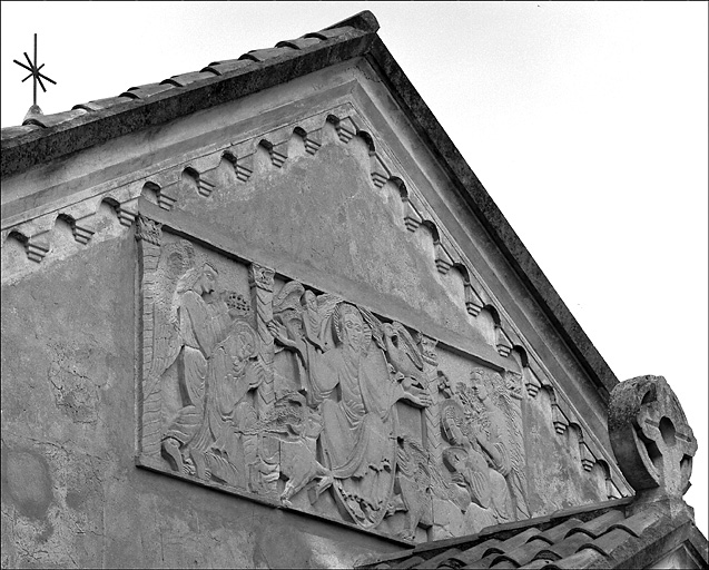 Chapelle. Détail, bas relief situé au-dessus du porche d'entrée représentant le Christ en gloire entouré du tétramorphe (au centre), encadré d'anges et de saints.