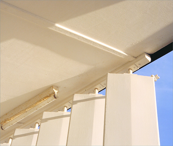 Système de fixation des lames du pare-soleil au plafond, sur la façade sud.