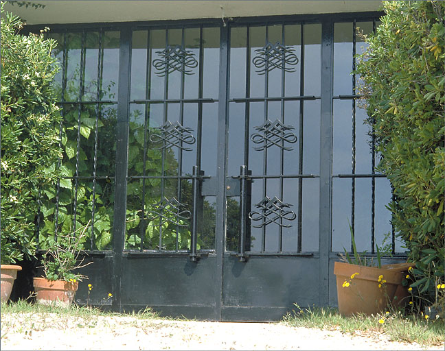 La porte d'entrée en ferronnerie, sur la façade sud, vue de face.
