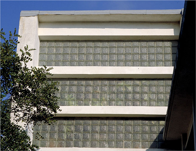 Vue de détail du mur ouest en pavés de verre sur le volume de la cage d'escalier.