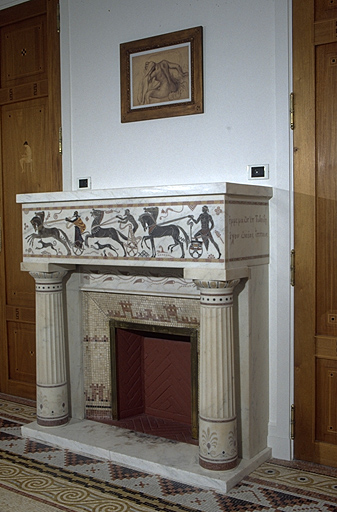 Cheminée en marbre sculpté inscrusté de pierres, dans le cabinet de travail - bibliothèque.