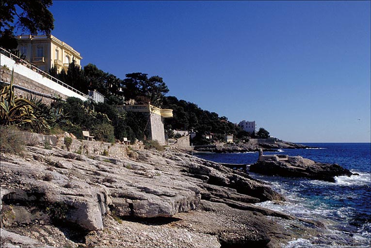 Vue perspective de la promenade du bord de mer située en contrebas de la villa Les Mouettes depuis l'ouest.