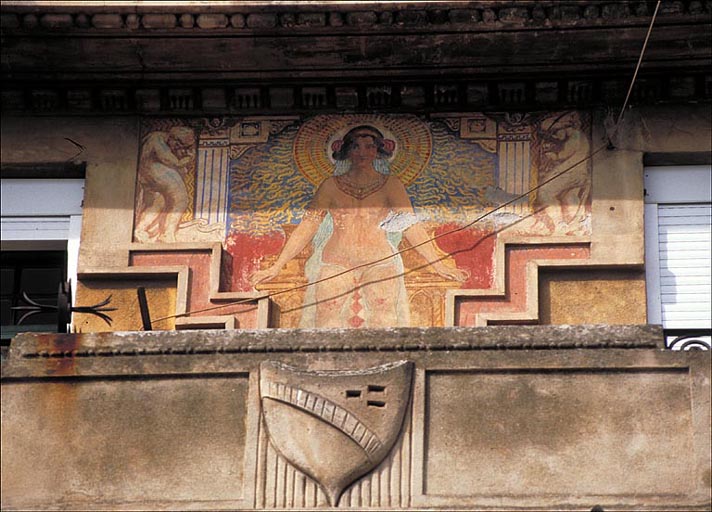 Détail : panneau peint et blason sculpté dominant la travée centrale de la façade sud, depuis le sud.