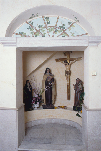 Croix et statues de sainte Rita de Cascia, sainte Thérèse de Lisieux, saint Antoine de Padoue.