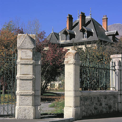 Détail du portail sur la rue : porte piétonne et pile portant le nom de la villa.