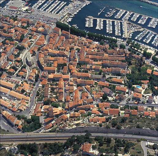 Vue aérienne du quartier de l'église, prise du nord en direction du sud : au premier plan la voie ferrée et le chemin de la Nerthe, à l'arrière-plan la voie littorale et le port de plaisance.